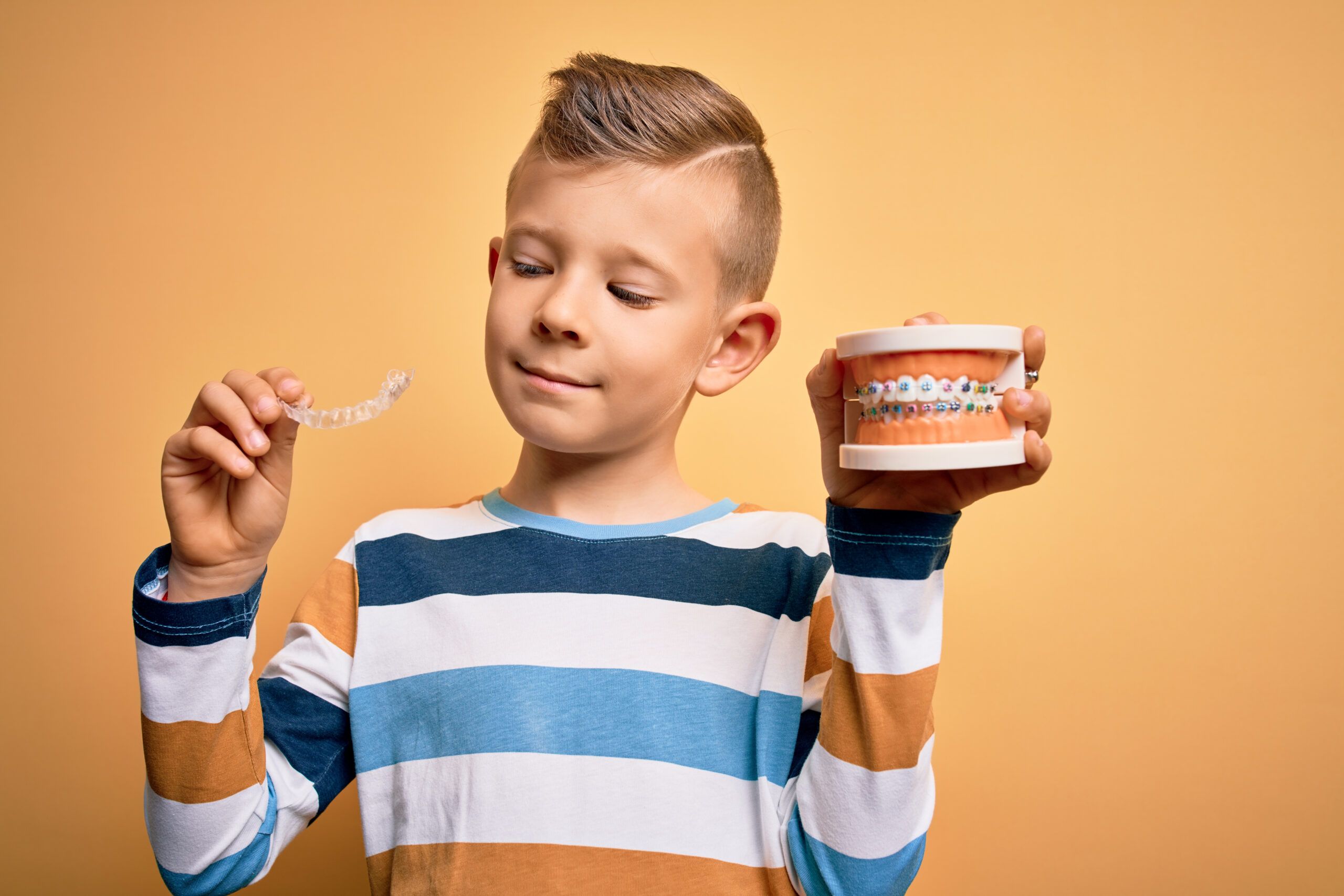 little boy holding orthodontic mold and retainer